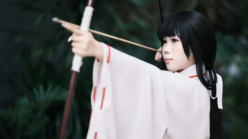 Bogenschützin in traditioneller japanischer Kleidung beim Auszug des Bogens
