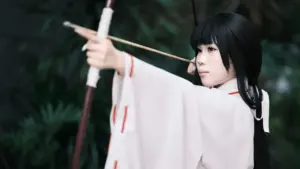 Bogenschützin in traditioneller japanischer Kleidung beim Auszug des Bogens